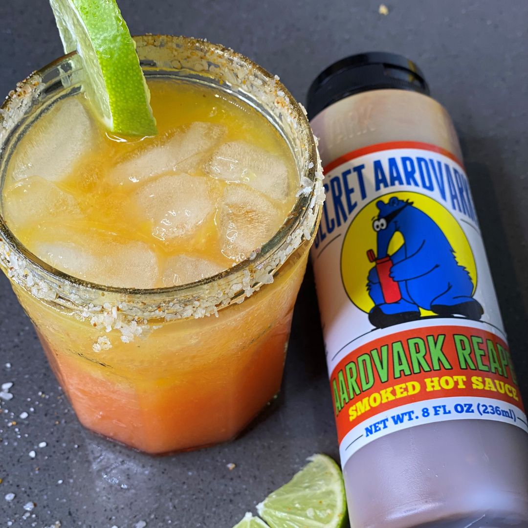 Aardvark Reaper Mango Margarita in a glass, garnished with a lime and salted rim.