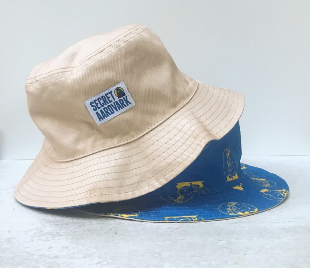 Tan bucket hat on top of blue bucket cap