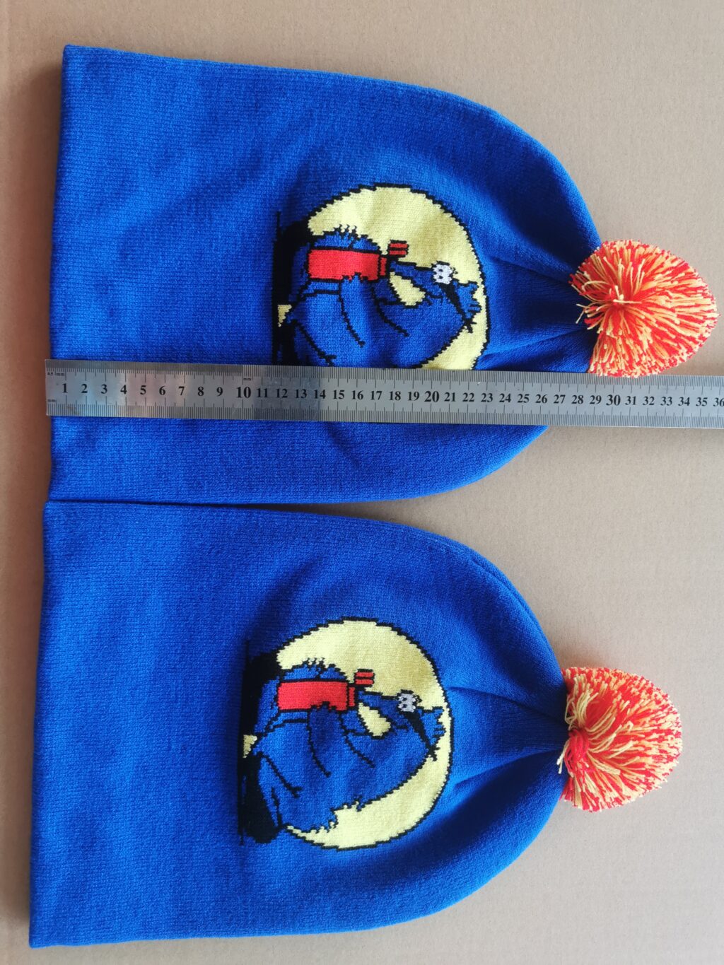 Two Aardvark beanies with ruler laying across them.