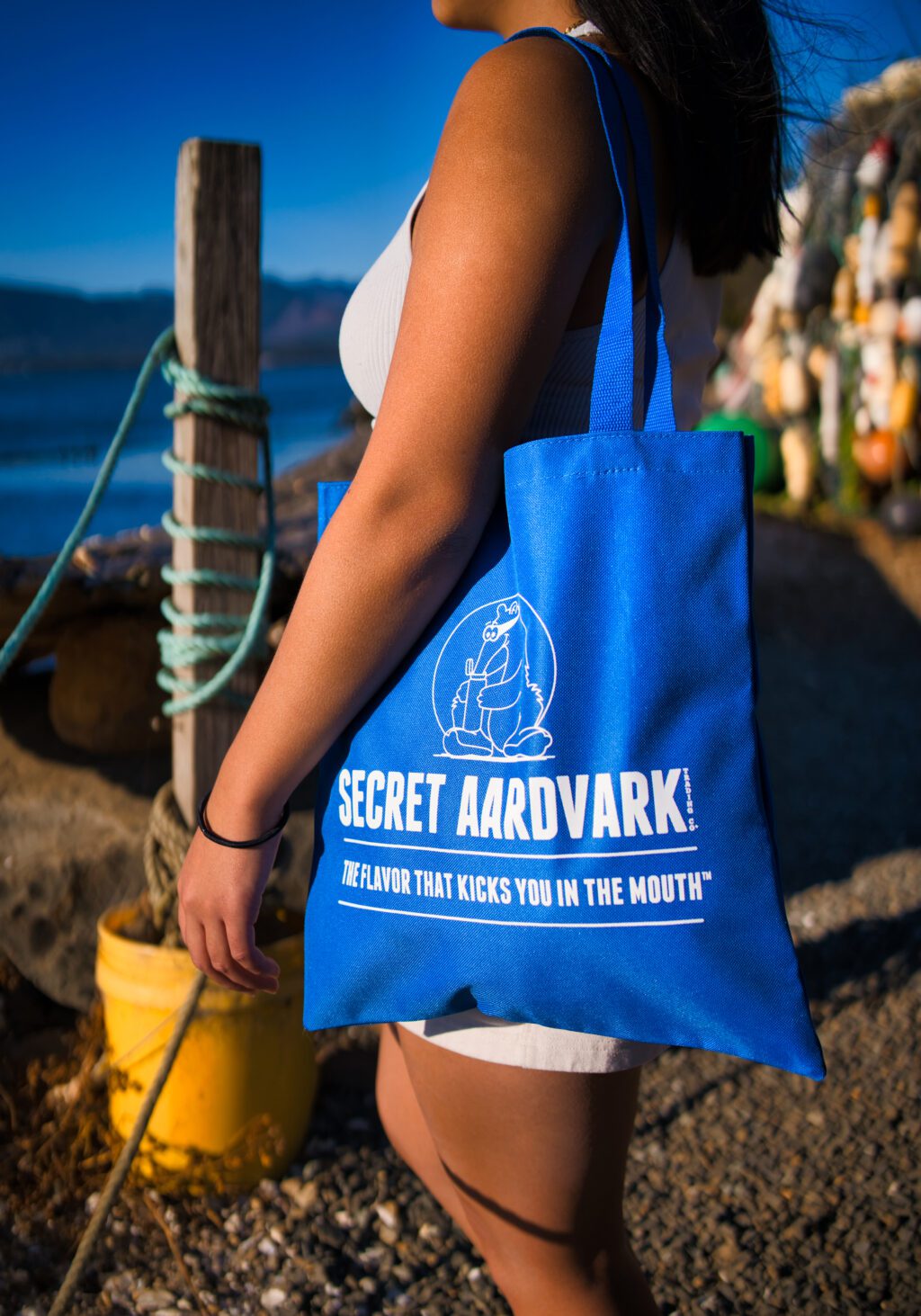 a woman holding a Secret Aardvark tote bag.