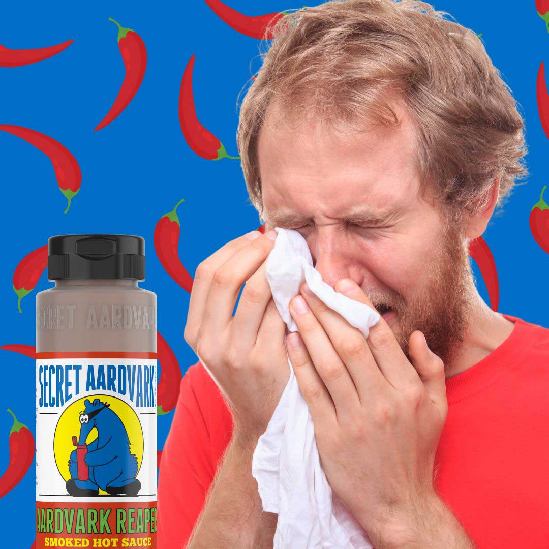 A guy crying with his mouth on fire from hot sauce.