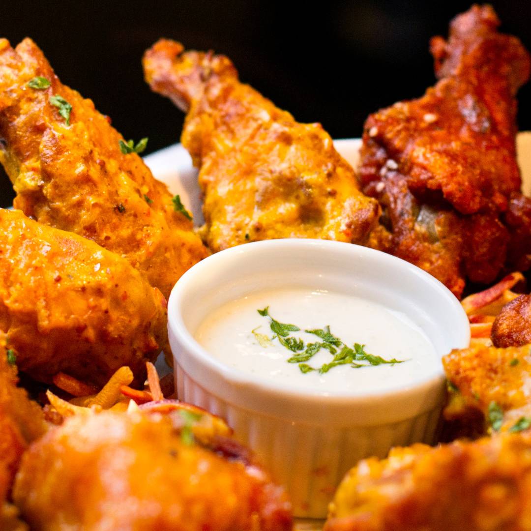 A delicious tray of Aardvark Scalding Scorpion Hot Wings with aside of ranch dressing.