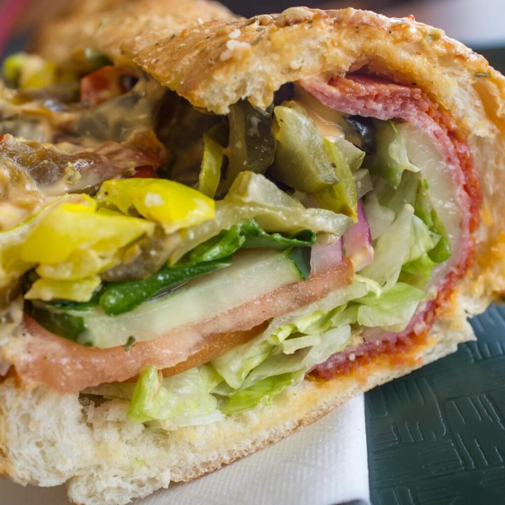 Drippy, drool-worthy close-up of a delicious Italian sub sandwich.