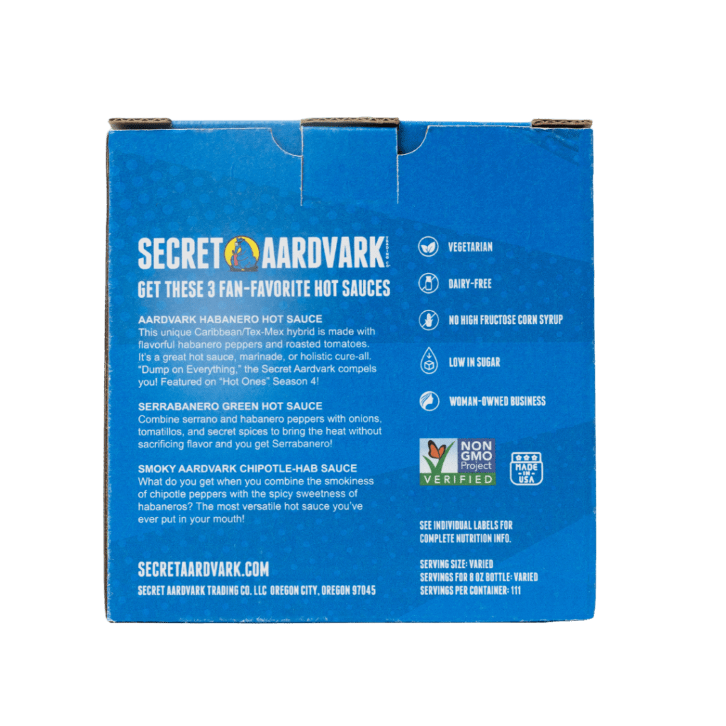 Backside of Blue 3pk Secret Aardvark Hot Sauce gift box. Box has description of the three hot sauces in box: Aardvark Habanero Hot Sauce, Serrabanero Green Hot Sauce, and Smoky Aardvark Chipotle-Hab Sauce.